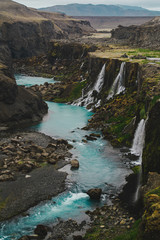 Scenic landscape view of incredible Sigoldugljufur canyon in highlands with turquoise river, Iceland. Volcanic landscape on background. Popular tourist attraction.