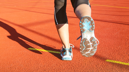 junge hübsche muskulöse Frau beim joggen - Detailansicht Sportschuh von hinten