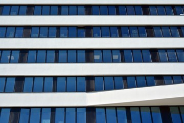 Facade fragment of a modern office building. Exterior of glass wall with abstract texture.