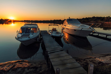 Boats near a pier at sunrise