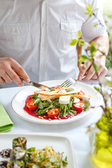 man in a restaurant is eating an appetizing salad. Close-up.