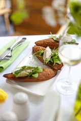Appetizing bruschetta with minced fish and herbs. Restaurant table setting.