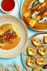Pancakes, a traditional dish of Russian national cuisine on a blue background. Traditional treat for the holiday Maslenitsa. Top view. Restaurant table setting