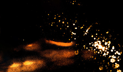 Fototapeta na wymiar Black background with golden sparkles. Blurred effect. Concept for festive background or for project