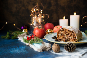 Christmas and New year dessert. Apple strudel with holiday lights.