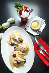 Pancakes, a traditional dish of Russian national cuisine on a black table. Restaurant serving. Top view.