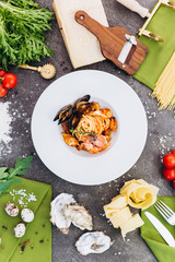 Pasta with king prawns on a gray background in a white dish.