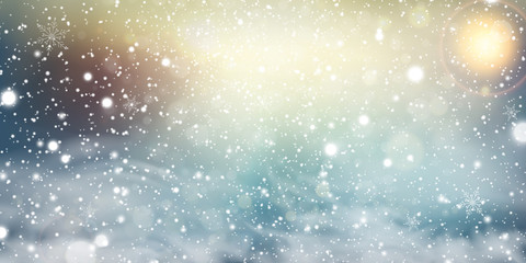 Christmas, Snowy Sunny day. Outdoors. Holiday winter landscape for Merry Christmas with Snowstorm, sun rays, blizzard, flying snow, snowflakes. Christmas scene. Happy new year