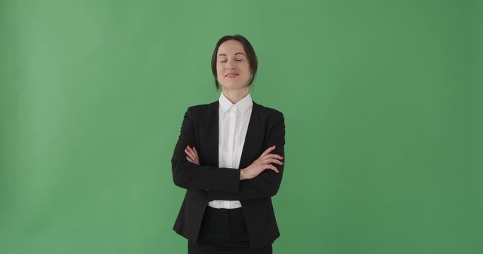 Successful businesswoman with arms crossed over green background
