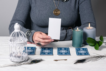 Fortune teller showing a blank tarot card in hand with a copy space for image.
