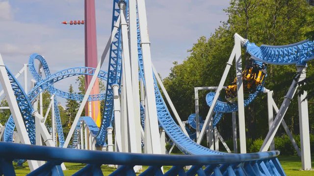 People ride on steel roller coaster in amusement park