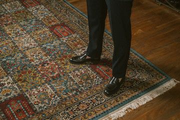 Men in a suit, standing on vintage carpet
