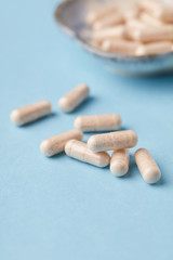 Ginkgo Biloba capsules. Dietary supplements. Bright paper background. Close up. Copy space. 