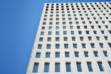 Modern office building detail. Perspective view of geometric angular concrete windows on the facade of a modernist brutalist style building. 