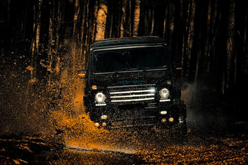 Obraz na płótnie Canvas Mud and water splash in off the road racing. Motion the wheels tires and off-road that goes in the dust on the sand. Safari suv. Off-road vehicle goes on mountain way.