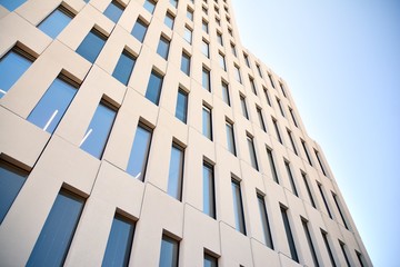 Modern office building detail. Perspective view of geometric angular concrete windows on the facade of a modernist brutalist style building. 