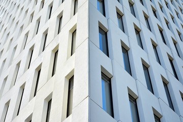 Modern office building detail. Perspective view of geometric angular concrete windows on the facade of a modernist brutalist style building. 