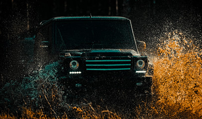 Mud and water splash in off road racing. Expedition offroader. Safari suv. Off-road vehicle goes on mountain way. 4x4 travel trekking. Motion wheels tires and off-road that goes in dust on sand. © Volodymyr
