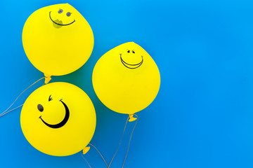 Happiness emotion. Yellow balloon with smile on blue background top view space for text