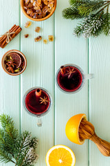 New Year composition with mulled wine and fir branches on green wooden background top view