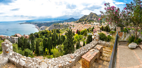 Panoramic aerial view of Ionian seacoast near Isola Bella island and Taormina old town on Sicily, Italy. Mt Etna on the background