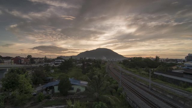 Timelapse Sunrise Over The KTM (Keretapi Tanah Melayu) Railway With The Train Moving.