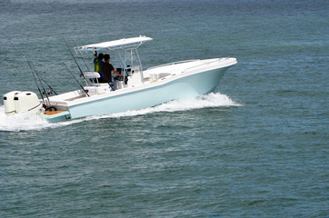 Light blue with white trim open sport fishing boat powered by two outboard engines