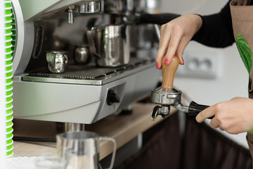 Barista girl is preparing aromatic coffee with a coffee machine. Barista work in a coffee shop