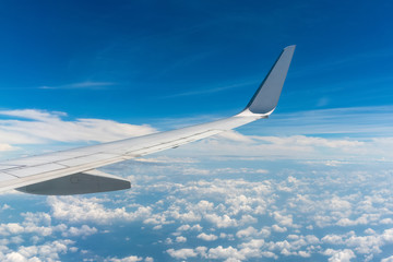 Fototapeta na wymiar an airplane wing over the cloudy blue sky