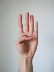 Hand show four fingers on white background