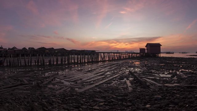 Timelapse Sunrise of the tide out to the sea at Tan jetty, clan jetty. Located between Chew Jetty and Lee Jetty. The houses are all built above the water.