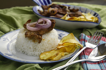 Bistek Tagalog or fried pork tenderloin in soy sauce with potato chips