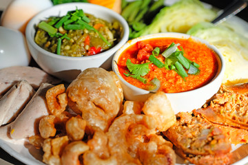 Thai food - Northern style red and green chilli dips with  northern thai spicy sausage (sai oua), streaky pork with crispy crackling and  vegetables