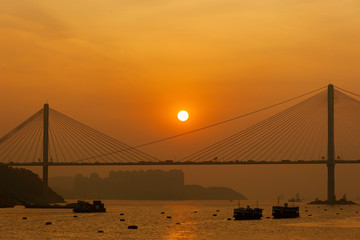 Obraz premium Sunset over suspension bridge in Hong Kong city