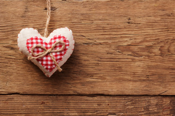 Handmade heart of scrim hanging on a wooden wall