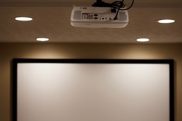 Basement home theater set up with projector and screen. Theatre with dimming lights and no windows