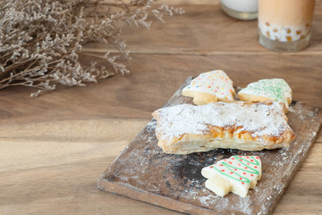 Dried bread with icing sugar and bread looklike Christmas tree on wooden table