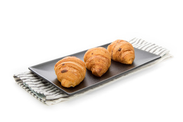 three cheese croissants on a modern black square plate isolated on white