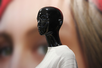 Black Mannequin On Background Of Photograph With Eyes