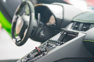 Interior photo of a Lamborghini sports car showing buttons and steering wheel - obrazy, fototapety, plakaty