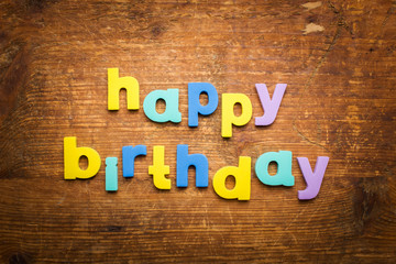 The words "HAPPY BIRTHDAY" on wooden background