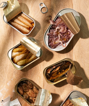 Canned Sea Food Fish on Wood Table  Muscles , Herring, Trout, Sardines, Mackerel, Octopus and Anchovies 