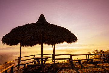 Thatched roof pavilionon the mountain with misty foggy in the valley at morning sunrise time