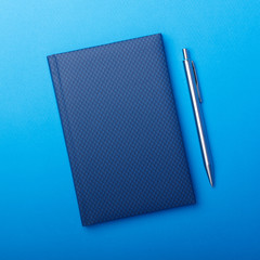 Blue notebook with pen on paper backgorund. Business work notepad.