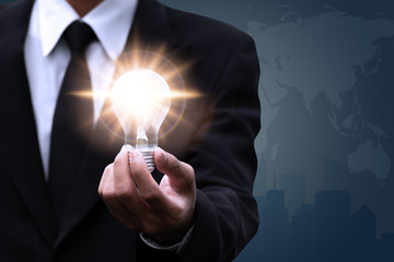 Hand of businessman holding illuminated light bulb,creative concept design.