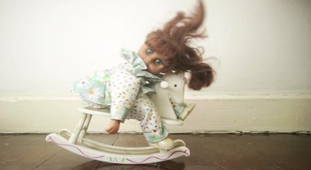 old doll on a rocking horse toned 