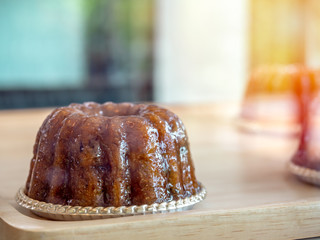 Tasty chocolate coffee pudding on foil plate on wooden shelf in bakery cabinet in cafe.