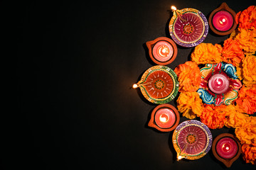 Happy Diwali - Clay Diya lamps lit during Dipavali, Hindu festival of lights celebration. Colorful traditional oil lamp diya on white background