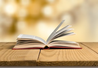 Open book on old wooden table.