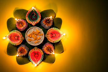 Happy Dussehra. Clay Diya lamps lit during Dussehra with yellow flowers, green leaf and rice on...